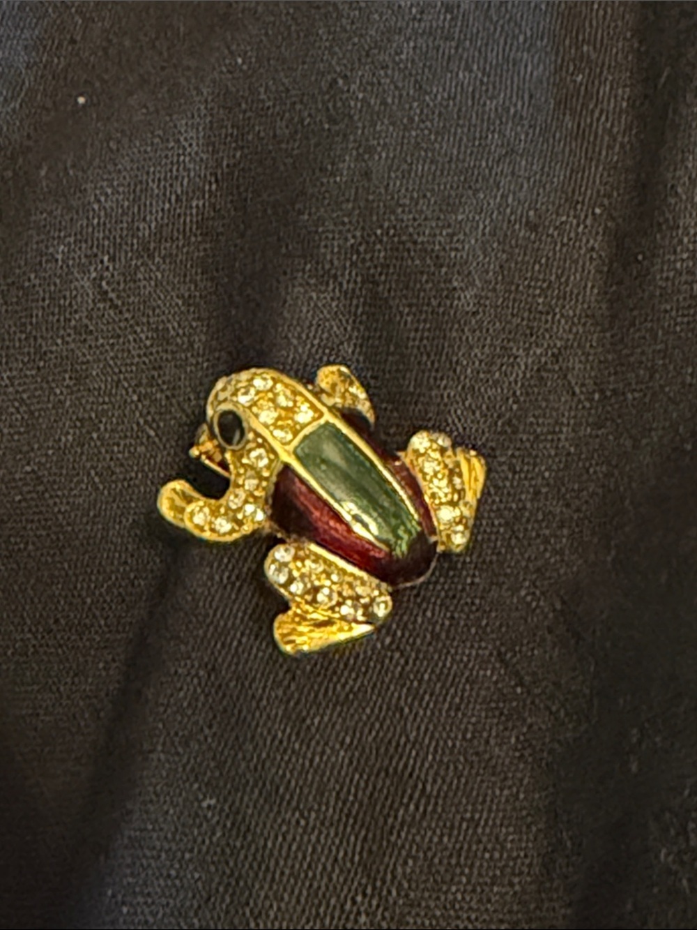 Cute gold tone frog enamel pin with rhinestones and enamel panels.